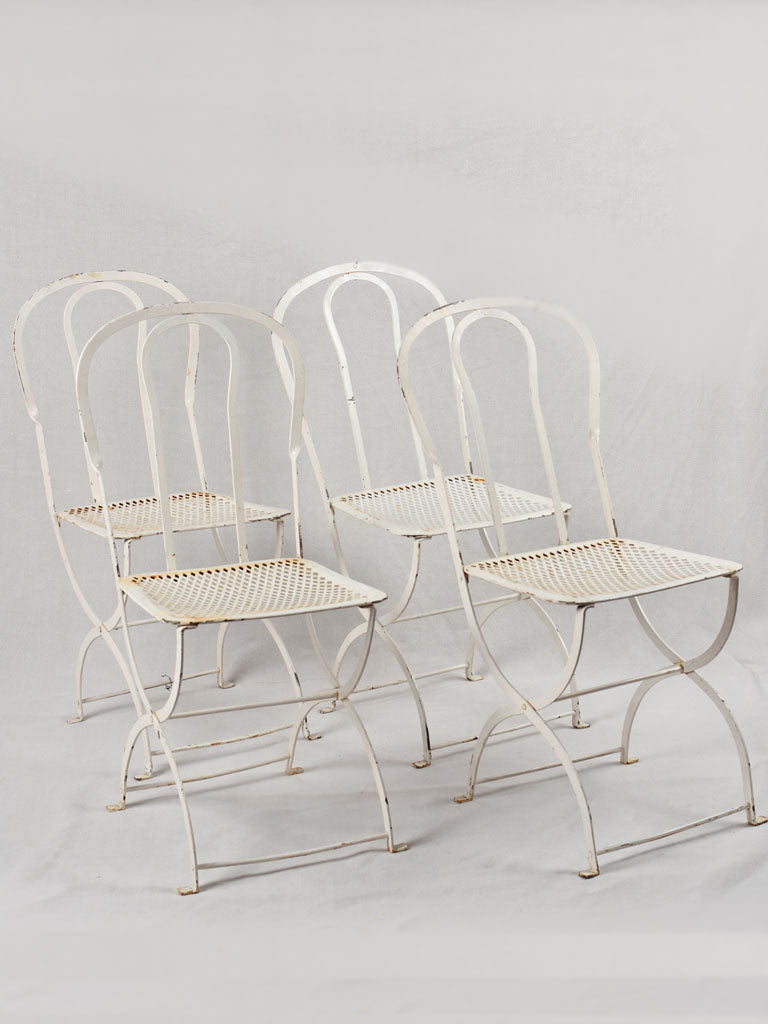 Set of four white folding garden chairs