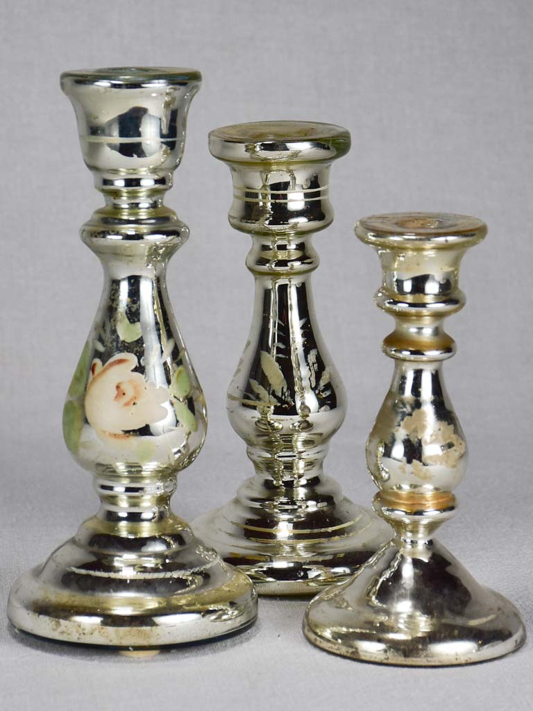 Three mercury glass candlesticks with flowers