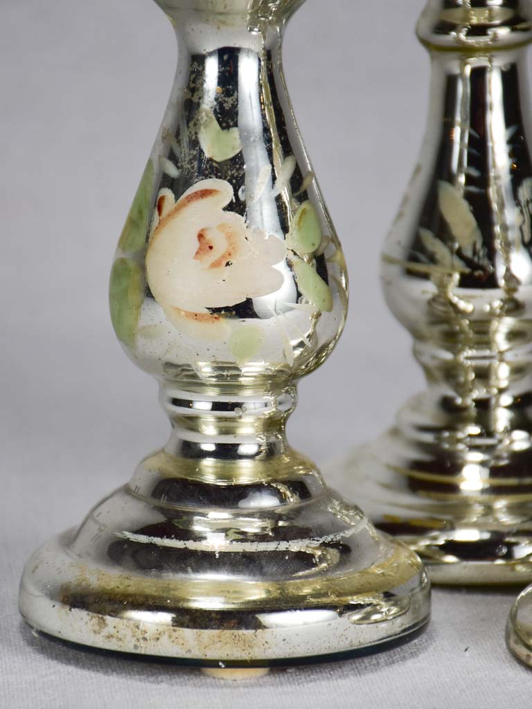 Three mercury glass candlesticks with flowers