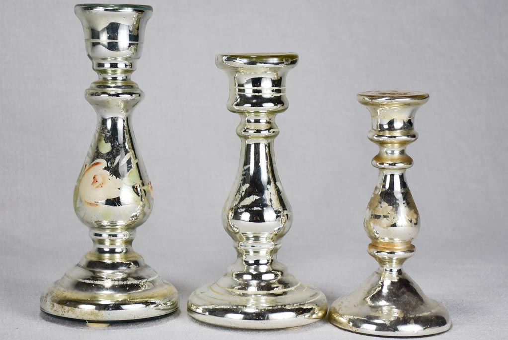 Three mercury glass candlesticks with flowers