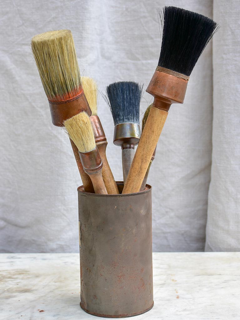 Collection of vintage paint brushes in a tin