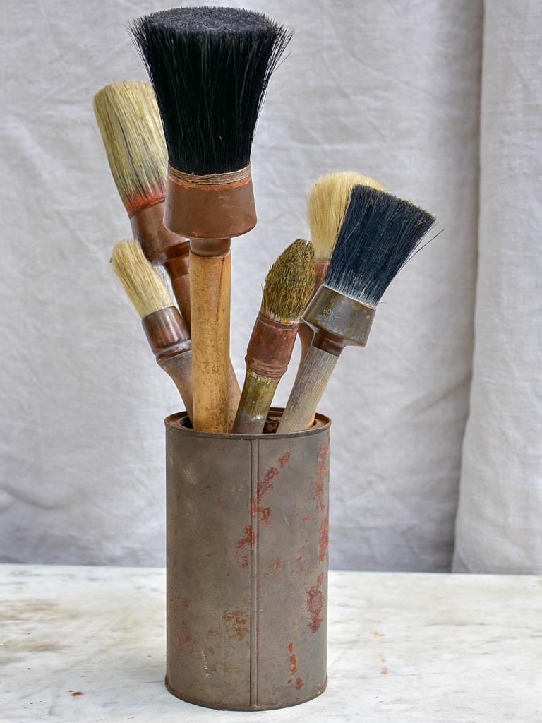 Collection of vintage paint brushes in a tin