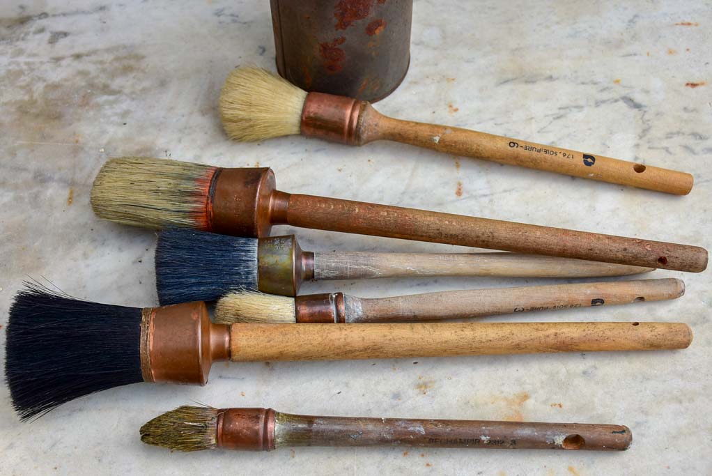 Collection of vintage paint brushes in a tin