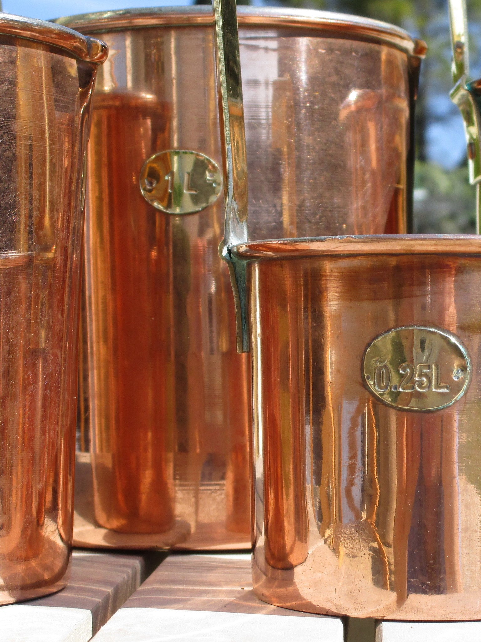 Set of five chef's copper measuring cups with brass detail