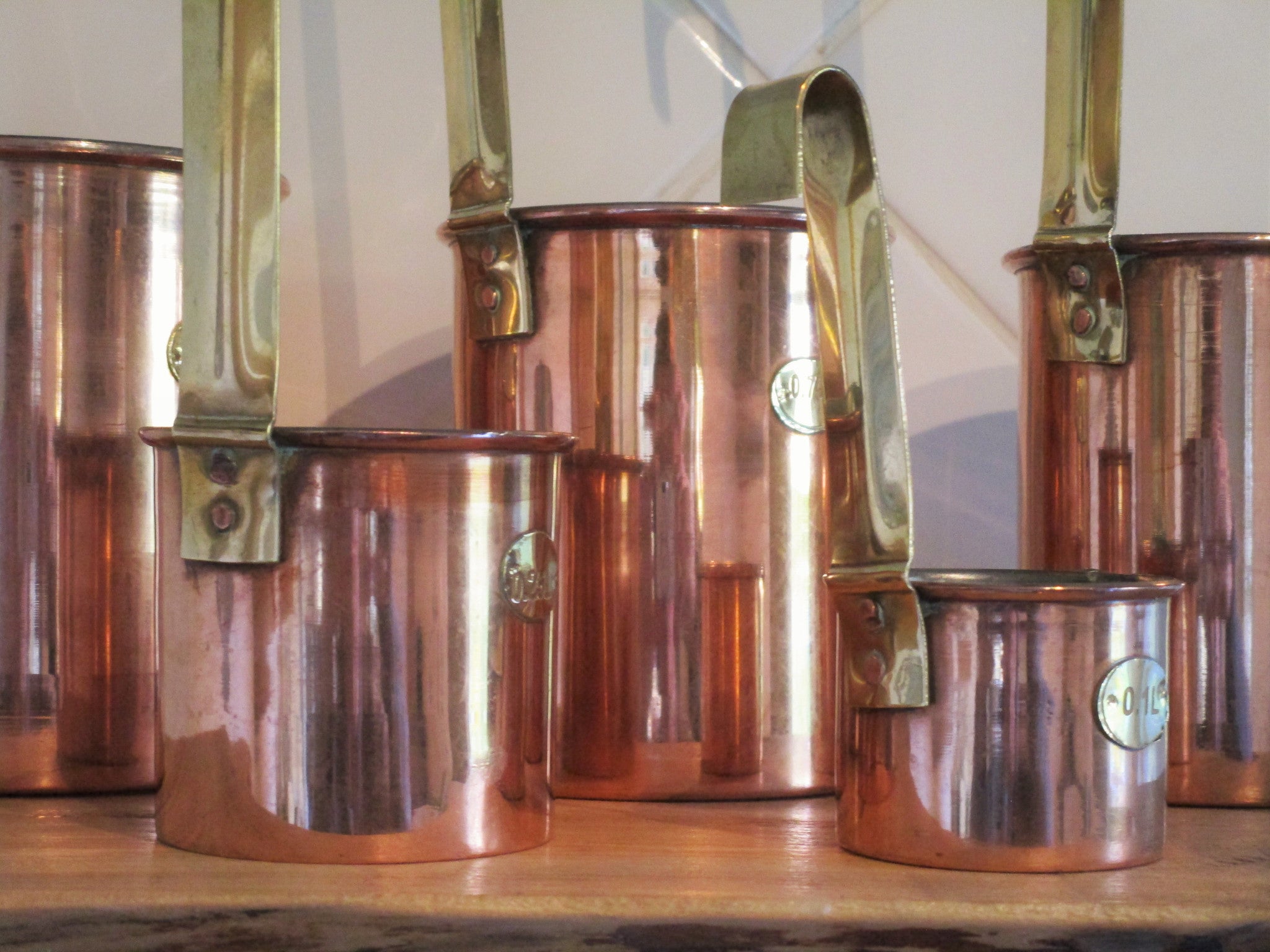 Set of five chef's copper measuring cups polished