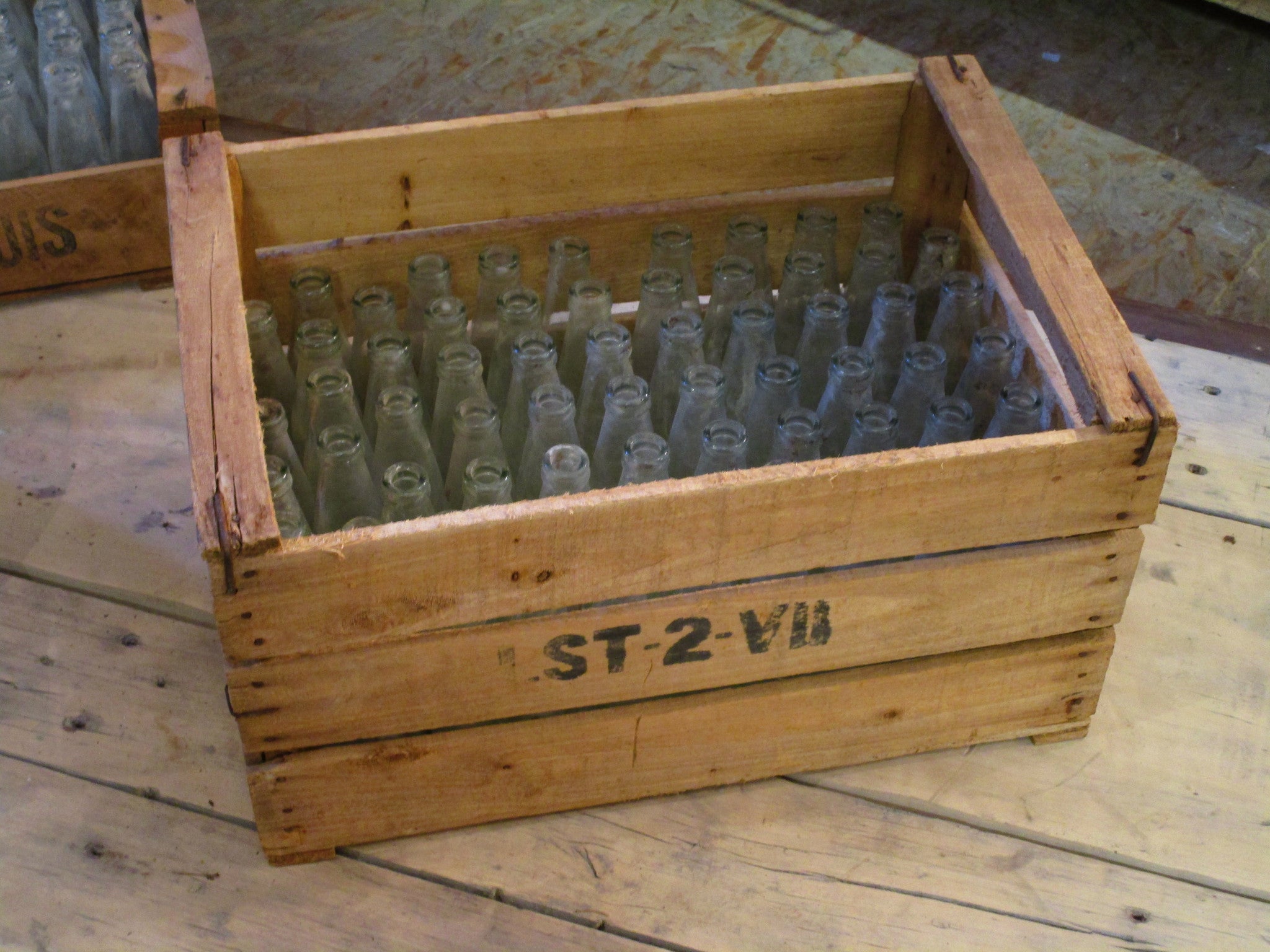 Rustic fruit box containing vintage glass bottles