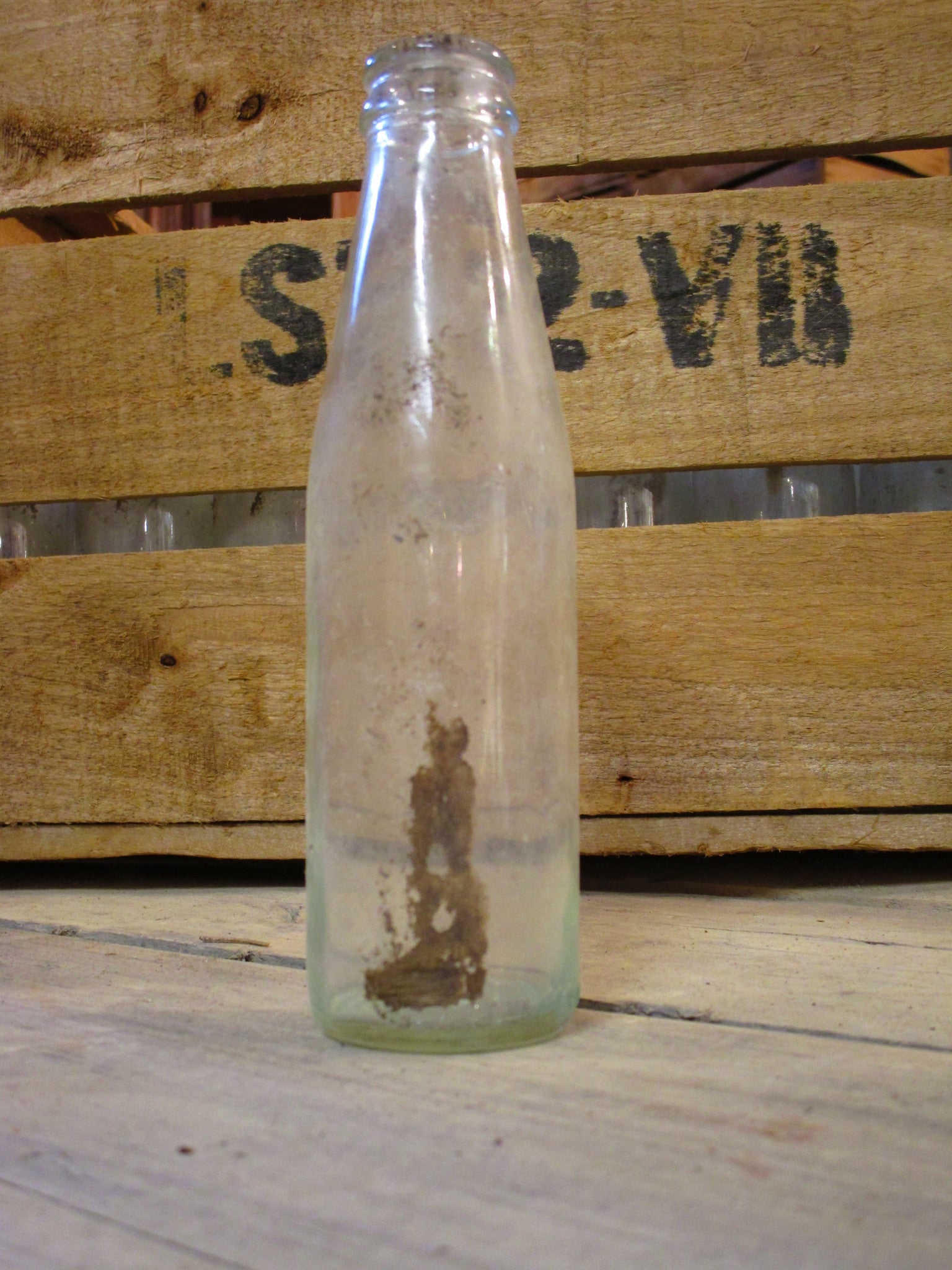 Rustic fruit box containing vintage glass bottles