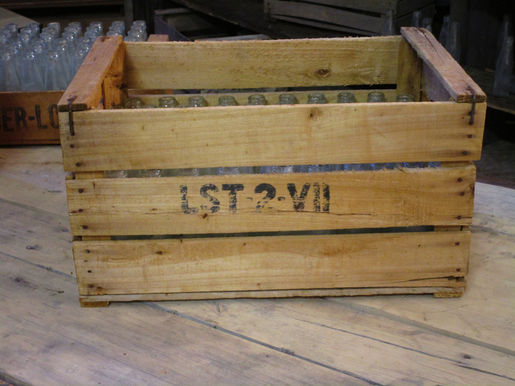 Rustic fruit box containing vintage glass bottles