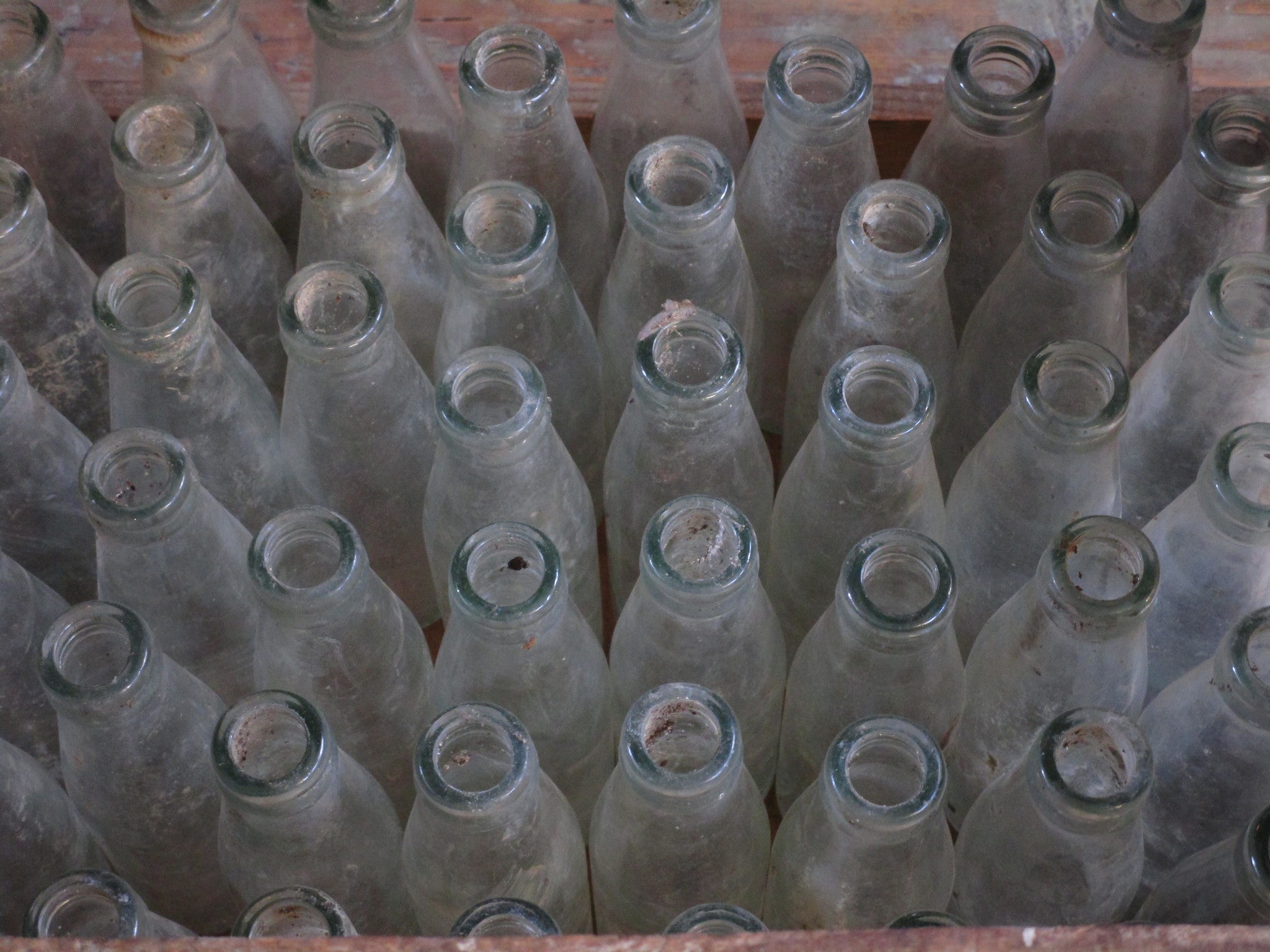 Vintage juice bottles in a rustic wooden box